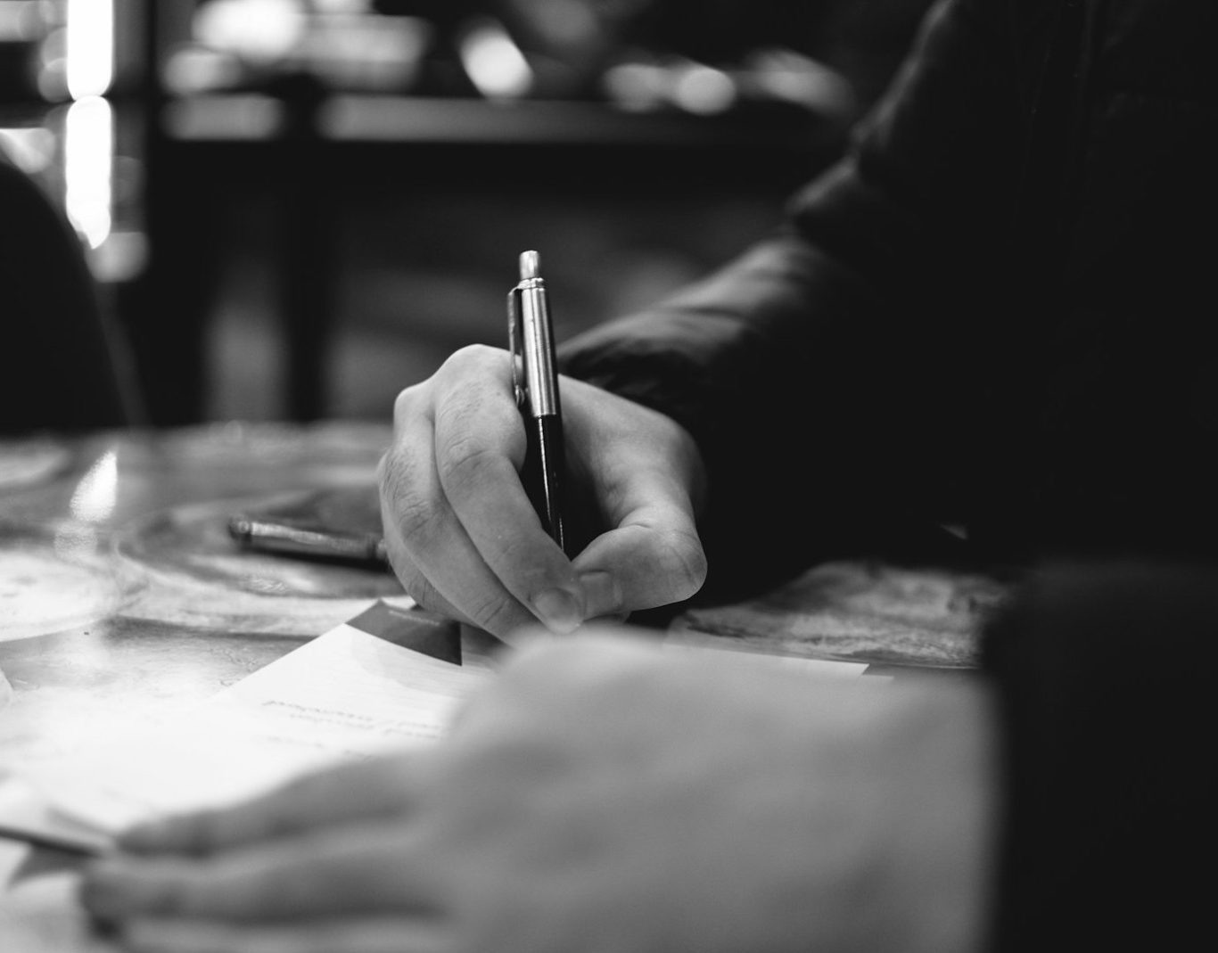 Main en train d'écrire avec un stylo sur une feuille de papier au cabinet d'expertise comptable intégral à grenoble